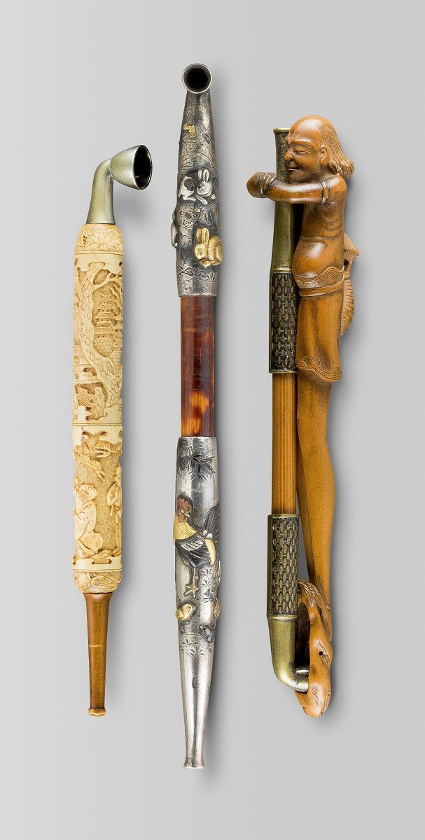 Pfeife mit figürlichen Schnitzereien aus Hirschhorn. Silberne Pfeife mit Hasen, Herbstblumen, Hahn und Henne als Dekor Senryuzutsu in Gestalt eines langbeinigen Mannes. Japan, Edo-Zeit (1602–1868). Foto: Jean Marie Colrat, St. Gratien